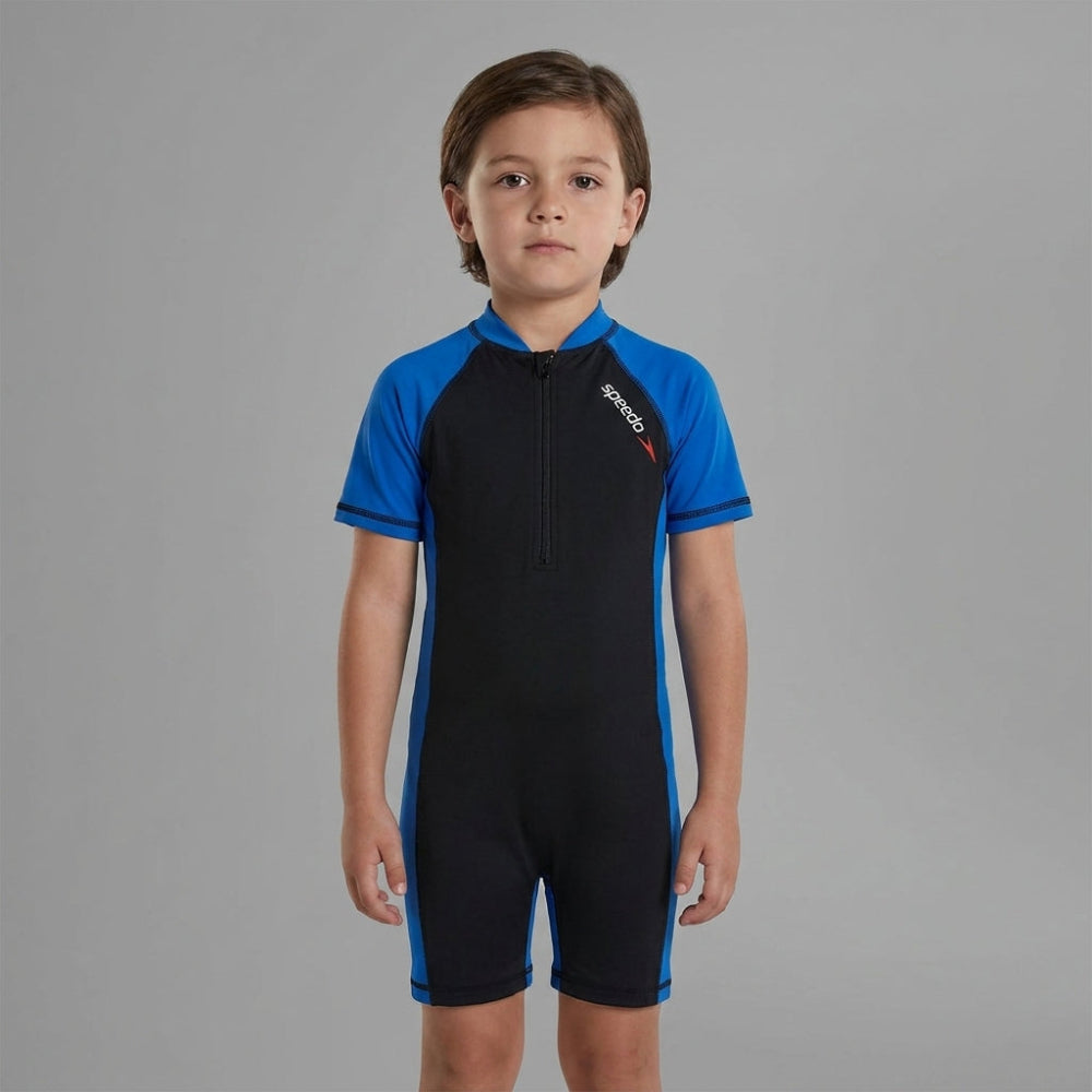 Child wearing a black and blue Speedo swimsuit on a gray background